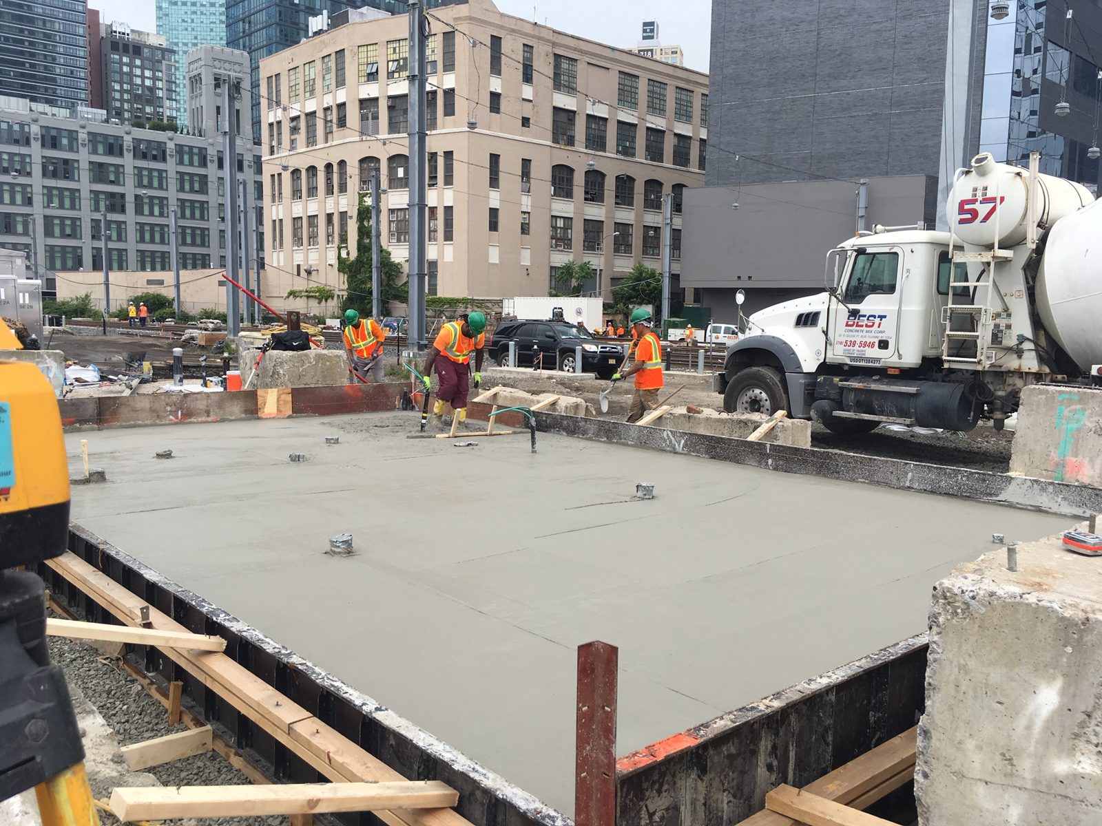 Construction crew finishing a poured concrete foundation on an infrastructure project