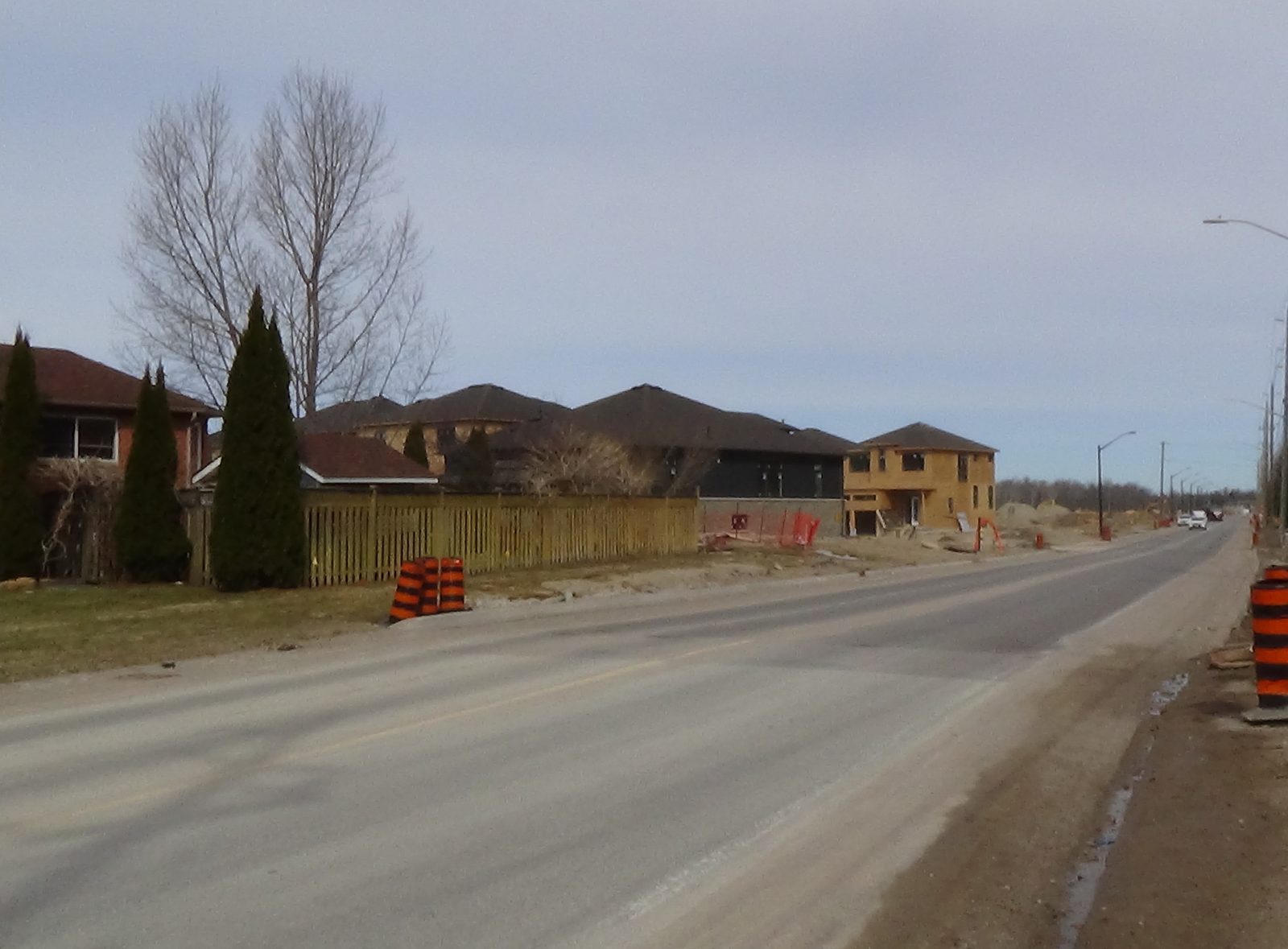 New residential subdivision street with fresh paving and homes under construction